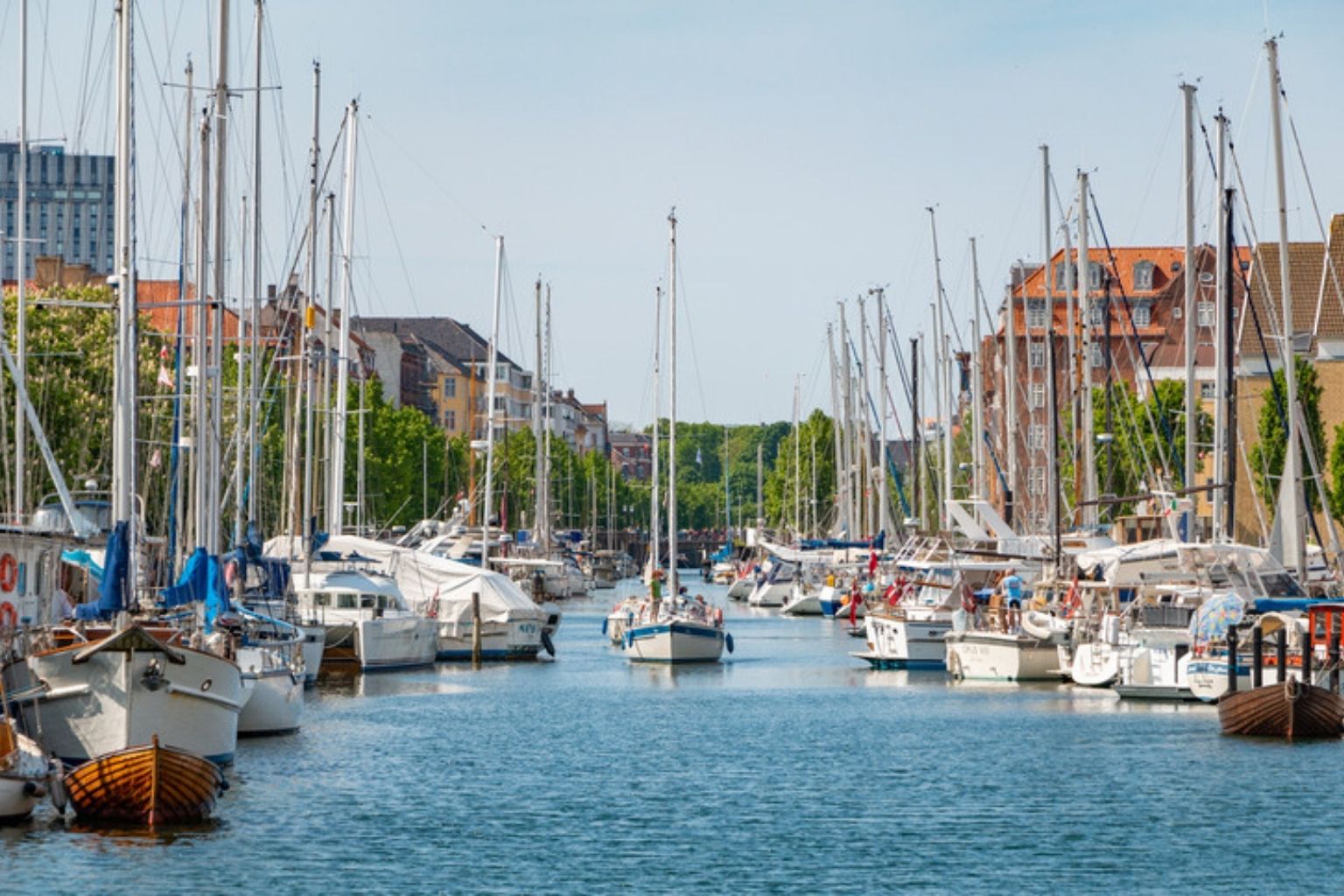 Kanal med sejlbåde og ældre huse på begge sider